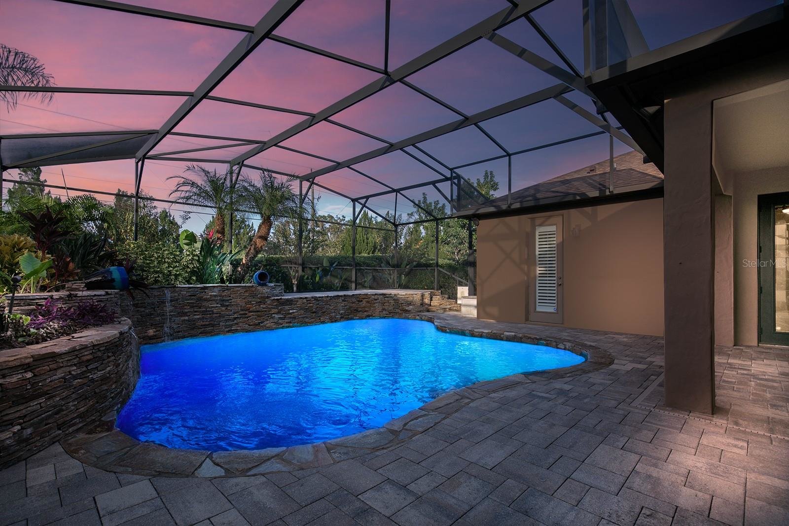 back enclosed patio with pool at night